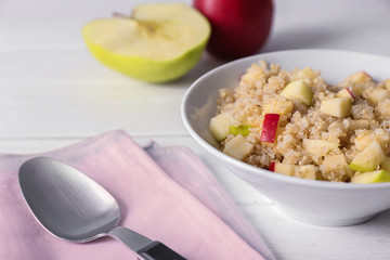 Bowl with cooked quinoa on kitchen table