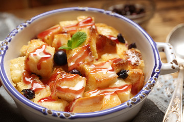 Delicious bread pudding with currant and jam in bowl
