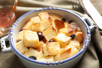 Delicious bread pudding with currant in bowl on napkin