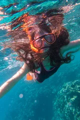 Tuinposter Duiken Girl in swimming mask diving in sea near coral reef