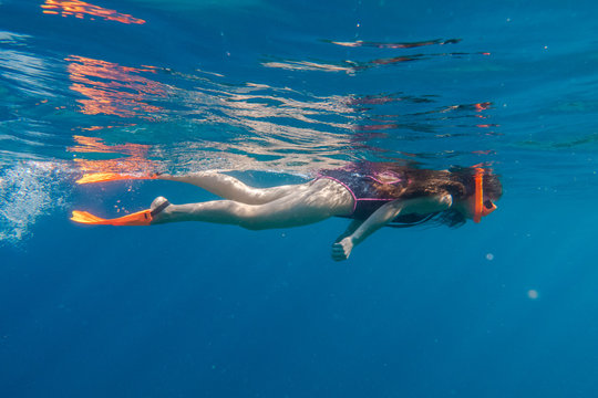 Girl In Orange Swimming Mask And Flippers Dive In Deep Sea