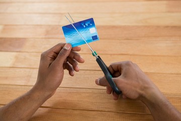 Businessman cutting credit card with scissors