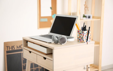 Modern stand-up desk with laptop in room