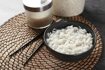 Bowl of rice and chopsticks on wicker mat