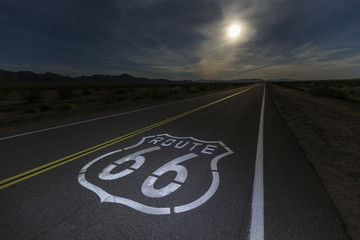 Route 66 sign with full moon in the California Mojave desert.  