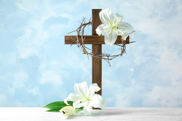 Composition with crown of thorns, cross and lily on light background