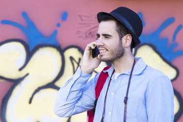 young man of modern style with mobile in the street