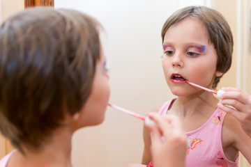 Beautiful little girl with lipstck