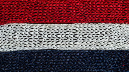 Knitted fragments of the flag colors: red, blue, white
