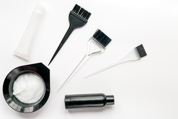 hair dye with brush on white table background top view
