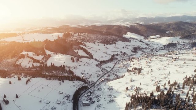 4K Aerial Drone View: Flight over Ski resort in winter. Mountain range with pine tree forest around. Majestic nature landscape. Bukovel, Carpathian Mountains, Ukraine