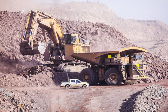 Big shovel loading of copper ore near to pickup truck