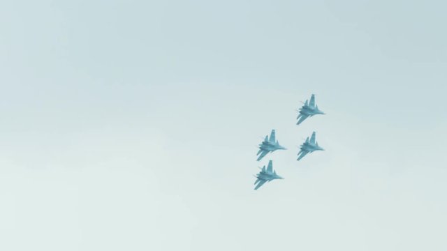 An su-35 Fighter Jet flying high above the clouds. Russian fighter flies a dangerous maneuver
