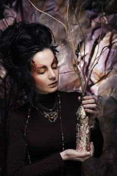 young luxury woman with bright makeup holding a bunch of dry twi