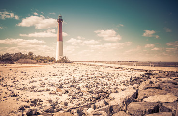 Obraz premium Barnegat Lighthouse in early spring with prominent rocks in foreground, New Jersey, USA