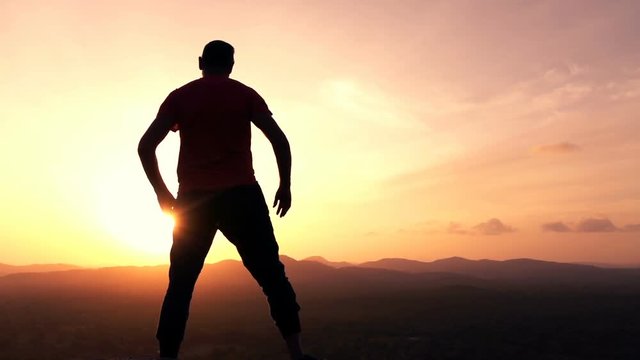 Silhouette of man admire sunset and landscape standing on hill, super slow motion 240fps
