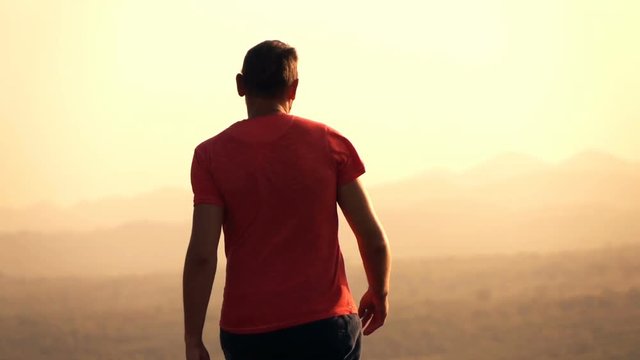 Man exploring, walking on hill during sunset, super slow motion 240fps
