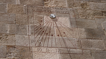 Close view of a sundial on a wall a sunny day at fort Montjuic in Barcelona, Spain