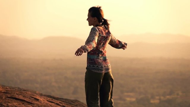 Happy woman dancing, rotating on hill during sunset, super slow motion 240fps
