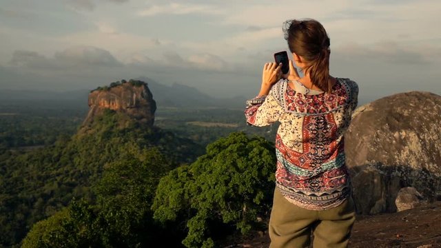 Woman taking photo of Lion Rock with cellphone in Sri Lanka, super slow motion 240fps
