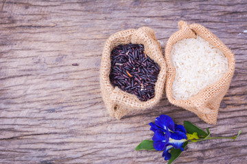 Black rice and Raw grain white rice in burlap bag on wood background,Jasmine rice,