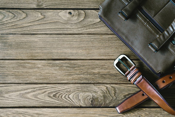 brown  leather belt and bag on the wooden table, top view with copy space