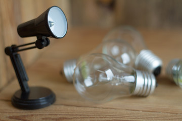 Small table lamp made of black plastic on a wooden background. 