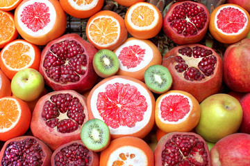Background pattern of different fruits: pomegranate, kiwi, orange, grapefruit close up