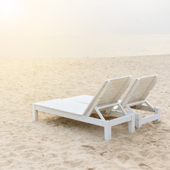 Two chairs on stunning tropical beach with bright sun