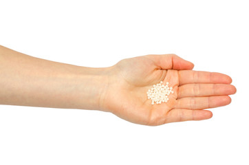 hand of young girl holding pills homeopathy.