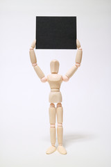 Wood mannequin has a card and is on a white background