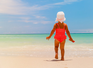 little girl going to swim at beach, tropical vacation