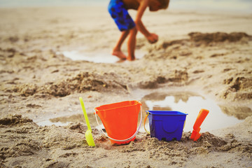 Fototapeta na wymiar kids toys and little boy playing on beach