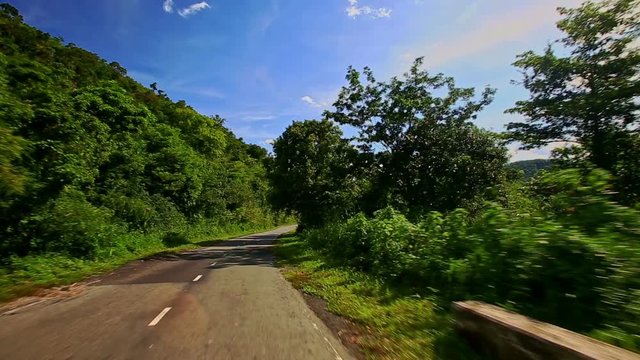 Camera Moves along Country Curvy Road among Hilly Landscape