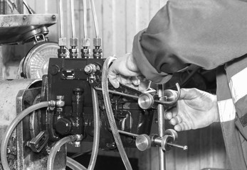 Professional mechanics testing diesel injector in his workshop, repair of diesel fuel injectors, ustroustvo for the diagnosis of fuel injectors