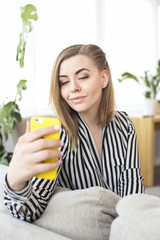 Happy woman with smartphone at home