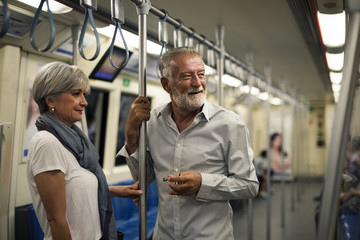 Senior couple traveling inside train subway