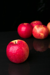 Fototapeta na wymiar Red apples on black background. Wet. Close up
