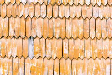 Old wall decorated with yellow retro wooden planks texture background