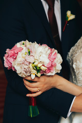 .Bride's bouquet on the background of the groom's jacket