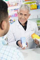 Obraz premium Senior Chemist Holding Products While Looking At Customer