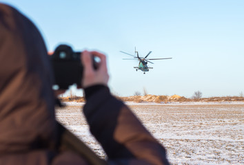 guy is taking pictures of low flying military helicopter