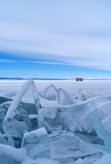 Fototapeta na wymiar Blue frozen water covered with snow at Baikal lake during winter