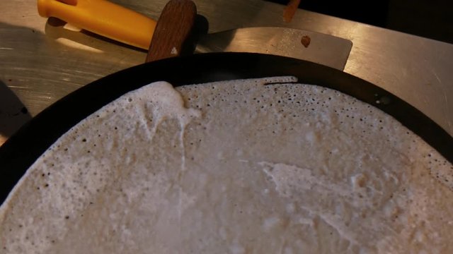 4K close up of a crepe cooking and heating, or buckwheat pancake, in Brittany. French traditional food specialty.  Galette bretonne, cr&ecirc;perie, Rennes, Bretagne, France.