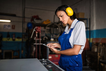 female mechanic checking status of a compressor engine using a tablet computer