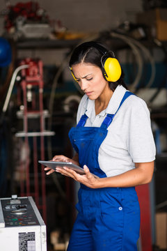 female mechanic checking status of a compressor engine using a tablet computer