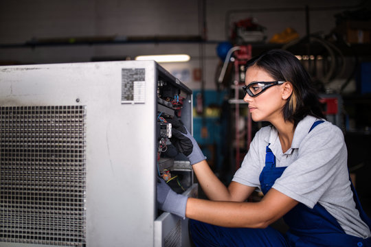 Female mechanic fixing a compressor engine