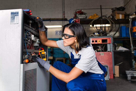 Female mechanic fixing a compressor engine