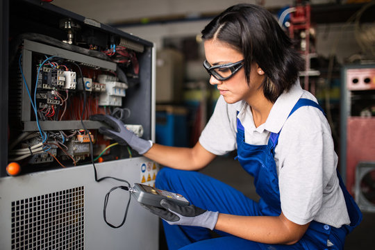 Female mechanic fixing a compressor engine