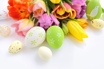 Fototapeta na wymiar Easter eggs with tulips flowers on white background